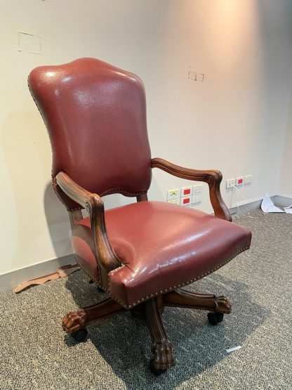 เก้าอี้สำนักงาน พักแขนและขาไม้แกะสลักขาสิงห์ เบาะหนังเทียม สีแดงเลือดหมู ตอกหมุดรอบตัว มีโช๊กปรับขึ้นลงได้ งานนำเข้า